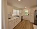 Modern kitchen with white cabinets, stainless appliances, and wood flooring, next to a door to the outside at 1802 19Th W Ave, Bradenton, FL 34205