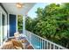 Balcony with wooden table and chairs overlooking a pool with a rock waterfall feature surrounded by lush landscaping at 211 65Th St, Holmes Beach, FL 34217