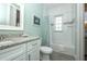 Bathroom with white cabinets, granite countertop, shower, coastal decor, and light-green walls at 211 65Th St, Holmes Beach, FL 34217