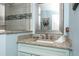 Bathroom featuring granite countertop, blue beadboard vanity, tiled corner shower and decorative mirror at 211 65Th St, Holmes Beach, FL 34217