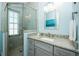 Bathroom featuring granite counters, neutral tiling, glass shower, and matching wall art at 211 65Th St, Holmes Beach, FL 34217