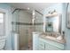 Bathroom featuring granite countertop, blue beadboard vanity, tiled corner shower and decorative mirror at 211 65Th St, Holmes Beach, FL 34217