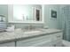 Bathroom featuring a granite countertop, white cabinets, stylish fixtures and a shower with patterned curtain at 211 65Th St, Holmes Beach, FL 34217