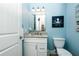 Bathroom showcasing white vanity, toilet, mirror and ocean themed wall decorations at 211 65Th St, Holmes Beach, FL 34217