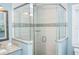Bright bathroom featuring a glass shower, decorative tiles, and a vanity with a granite countertop at 211 65Th St, Holmes Beach, FL 34217
