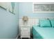 Light-filled bedroom showing a bedside table, lamp, and a window with blinds at 211 65Th St, Holmes Beach, FL 34217