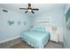 Cozy bedroom features blue bedding, coastal artwork, a ceiling fan, and lots of natural light at 211 65Th St, Holmes Beach, FL 34217