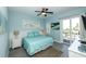 Comfortable bedroom with blue bedding, a ceiling fan, and a private balcony overlooking the outdoors at 211 65Th St, Holmes Beach, FL 34217