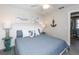Bright bedroom with a queen-sized bed, white headboard, nautical decor, and ensuite bathroom at 211 65Th St, Holmes Beach, FL 34217