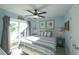 Bright bedroom with balcony access, ceiling fan, light blue walls, and coastal decor at 211 65Th St, Holmes Beach, FL 34217