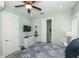 Cozy bedroom has light-green walls, coastal decorations, a ceiling fan, and an ensuite bathroom at 211 65Th St, Holmes Beach, FL 34217