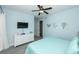 Stylish bedroom features a ceiling fan, a dresser with a TV, and cool blue wall art at 211 65Th St, Holmes Beach, FL 34217