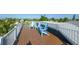 Roof top deck with blue Adirondack chairs and wooden deck flooring at 211 65Th St, Holmes Beach, FL 34217