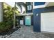 A colorful teal door offers a bright pop of color against the home's navy facade at 211 65Th St, Holmes Beach, FL 34217