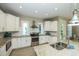 Charming kitchen with white cabinetry, granite countertops, and stainless steel appliances, enhanced by natural light at 211 65Th St, Holmes Beach, FL 34217