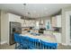 Bright kitchen features stainless steel appliances, granite countertops, and a large island with blue bar stools at 211 65Th St, Holmes Beach, FL 34217