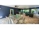 Outdoor living space with a dining table, grill, ceiling fans and comfortable seating area for relaxing at 211 65Th St, Holmes Beach, FL 34217