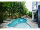 Backyard oasis featuring a pool with slide and spa surrounded by lush landscaping for ultimate relaxation at 211 65Th St, Holmes Beach, FL 34217
