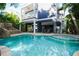 Inviting pool area with a slide and steps, surrounded by lush landscaping and the home's architectural details at 211 65Th St, Holmes Beach, FL 34217