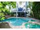Luxurious backyard with a pool, spa, rock slide, and outdoor seating, perfect for relaxation and entertaining at 211 65Th St, Holmes Beach, FL 34217