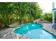 Backyard features a sparkling pool with a built-in spa, waterslide, and lush tropical landscaping at 211 65Th St, Holmes Beach, FL 34217