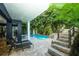 Inviting pool area with lounge chairs, stone steps, and waterslide, surrounded by tropical foliage at 211 65Th St, Holmes Beach, FL 34217
