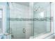 Spacious shower with glass door and white tile featuring decorative gray tile stripe at 211 65Th St, Holmes Beach, FL 34217