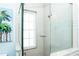 Bathroom shower featuring neutral tiling, a glass surround, granite sills and window at 211 65Th St, Holmes Beach, FL 34217