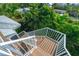 Aerial view of outdoor staircase with white railings, wood steps, and tropical foliage surrounding a coastal property at 211 65Th St, Holmes Beach, FL 34217