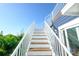 Bright outdoor stairway with white railing leading up to a balcony at 211 65Th St, Holmes Beach, FL 34217