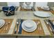 Close-up of an elegant table setting with woven placemats, blue accents, and decorative starfish centerpiece at 211 65Th St, Holmes Beach, FL 34217