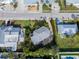 Aerial view of coastal home with gray roof surrounded by lush landscaping and neighboring houses at 221 85Th St, Holmes Beach, FL 34217
