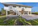 The home has a staircase to the second floor with a covered area beneath and a patio made of brick pavers at 221 85Th St, Holmes Beach, FL 34217