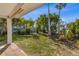 Lush backyard featuring mature trees, garden area, and partial paver patio at 221 85Th St, Holmes Beach, FL 34217