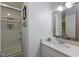 Well-lit bathroom with a framed mirror, white cabinets, and glass-door shower at 221 85Th St, Holmes Beach, FL 34217