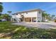 Exterior view of raised home with white columns, stairs, and landscaped yard with paver driveway at 221 85Th St, Holmes Beach, FL 34217