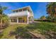 Exterior view of raised home with white columns, stairs, and landscaped yard at 221 85Th St, Holmes Beach, FL 34217