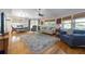 An open-concept living room with hardwood floors, a ceiling fan, lots of natural light, and comfortable furnishings at 221 85Th St, Holmes Beach, FL 34217
