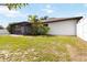 A view of the rear of the house, featuring an enclosed lanai and lawn at 2477 Wood Oak Dr, Sarasota, FL 34232