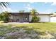 A view of the rear of the house, featuring an enclosed lanai and lawn at 2477 Wood Oak Dr, Sarasota, FL 34232