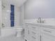 Updated bathroom features a shower-tub combo with blue tile accent and a vanity with white marble countertop at 2477 Wood Oak Dr, Sarasota, FL 34232