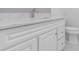 Close-up view of a well-lit bathroom vanity with a marble countertop and white cabinets at 2477 Wood Oak Dr, Sarasota, FL 34232