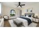 Stylishly furnished bedroom with a ceiling fan, an arched window, and decorative wall art at 2477 Wood Oak Dr, Sarasota, FL 34232