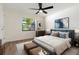 Bedroom with modern decor, a ceiling fan, and a large window with a tropical view at 2477 Wood Oak Dr, Sarasota, FL 34232