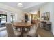 Dining area open to kitchen featuring neutral-toned walls and modern light fixture at 2477 Wood Oak Dr, Sarasota, FL 34232