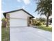 Single-story home with a two-car garage, stone veneer accents and driveway at 2477 Wood Oak Dr, Sarasota, FL 34232