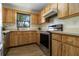 The kitchen has stainless steel appliances and wood cabinets, all with a view of tropical greenery at 2477 Wood Oak Dr, Sarasota, FL 34232