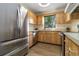 Well-lit kitchen boasts wooden cabinets, stainless steel appliances, and a view of lush greenery at 2477 Wood Oak Dr, Sarasota, FL 34232