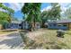 Large backyard with a trampoline, blue house with a red door, fire pit, and blue shed at 2509 8Th W Ave, Bradenton, FL 34205
