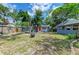 Large backyard with a fire pit, trampoline, and a blue house with a red door at 2509 8Th W Ave, Bradenton, FL 34205